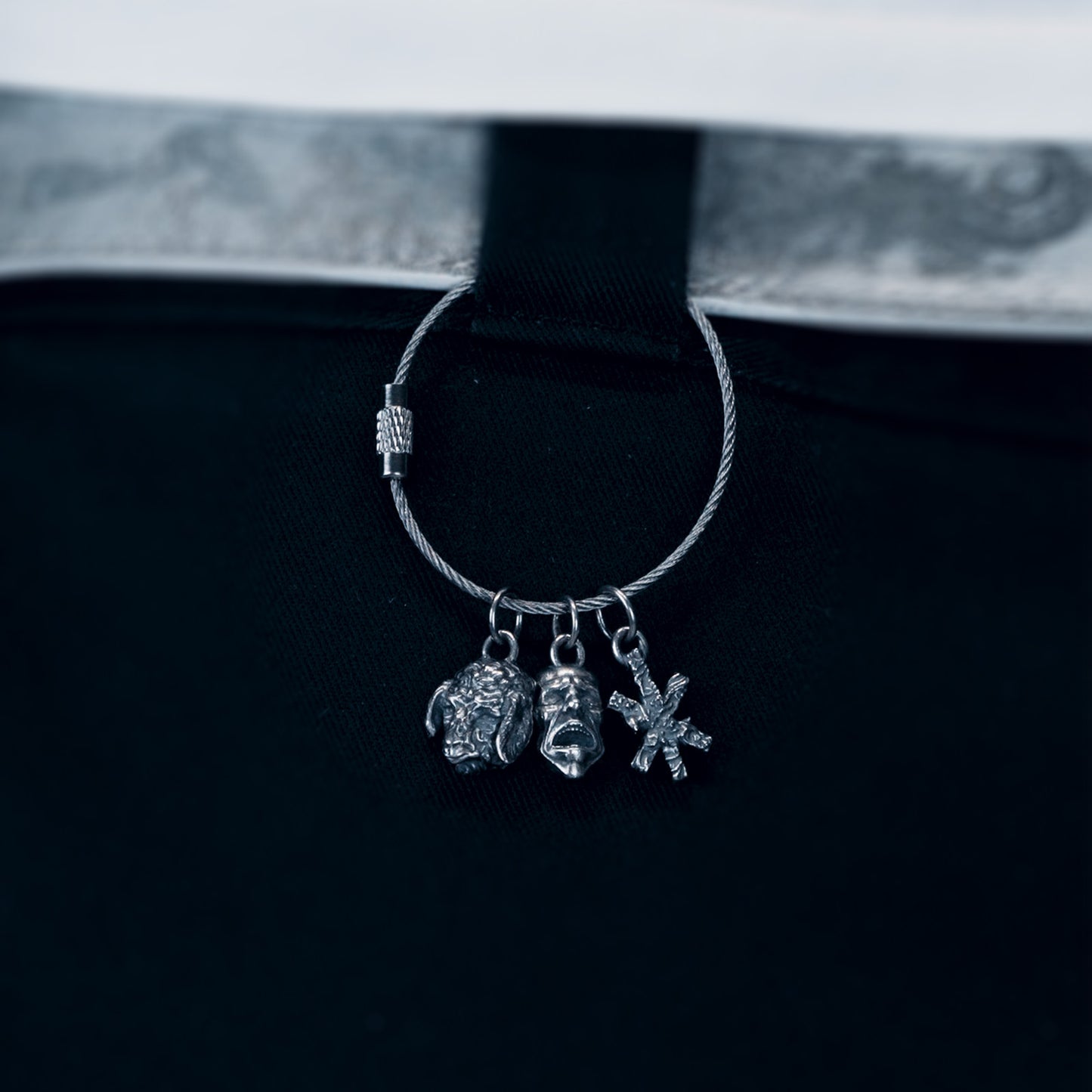 Silver hoop earring with charms on a black background