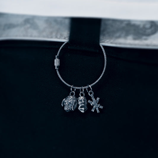 Silver hoop earring with charms on a black background