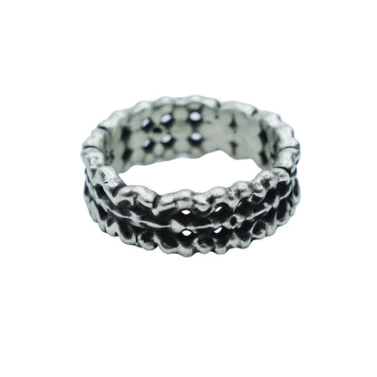 Silver ring with textured design on a light gray background