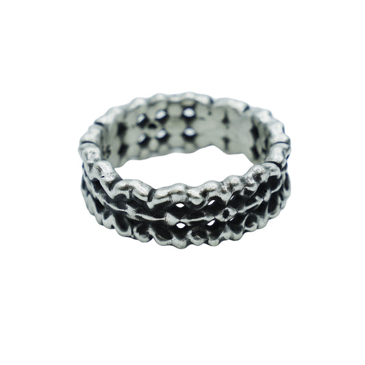 Silver ring with textured design on a light gray background