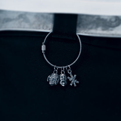 Silver hoop earring with charms on a black background