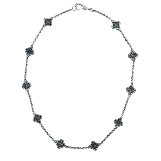Silver necklace with square black stone pendants on a white background